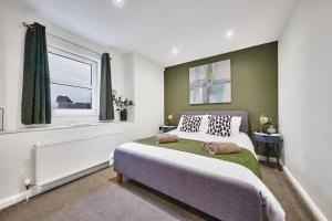 斯图尔特港Portstewart Central Loft Apartment的一间卧室设有一张床和一个窗口
