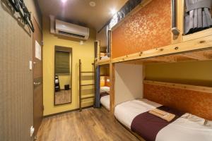 东京IKIDANE Cozy Hotel Haneda Airport - Vacation STAY 25834v的配有两张双层床的客房,设有黄色的墙壁和木地板