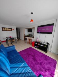 拉塞雷纳Arriendo Diario En La Serena的客厅配有蓝色的沙发和紫色地毯