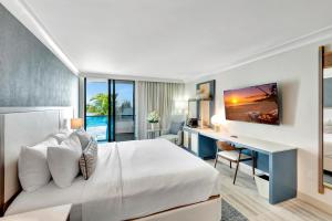棕榈滩Tideline Palm Beach Ocean Resort and Spa的配有一张床和一张书桌的酒店客房