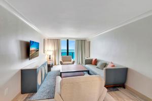 棕榈滩Tideline Palm Beach Ocean Resort and Spa的客厅配有沙发和桌子