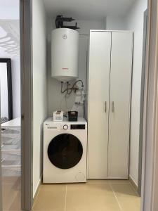 特拉萨Luminoso dúplex con parking的厨房配有洗衣机和白色橱柜。