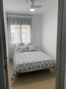特拉萨Luminoso dúplex con parking的卧室内的一张床位,配有吊扇