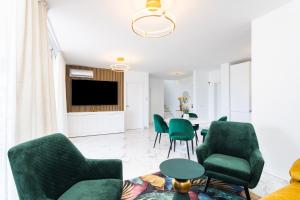阿德耶Elysium Ocean Villa的客厅配有绿色椅子和桌子