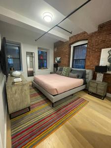 纽约Large 3 bedroom in Flatiron的一间卧室配有一张床、一张沙发和一台电视。