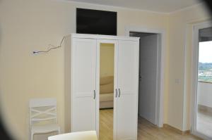 蒙特科尔维诺-罗韦拉La Vecchia Lanterna的一间房间,上面有电视,有白色的橱柜