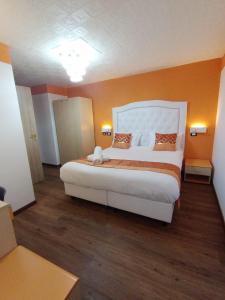 热那亚韦罗内塞酒店的卧室配有白色大床和橙色墙壁