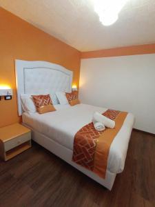 热那亚韦罗内塞酒店的一间卧室配有一张带橙色墙壁的大床