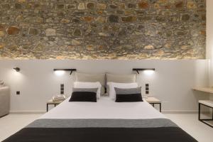 Skála LoutrónZaira Hotel的一间卧室设有一张大床和石墙