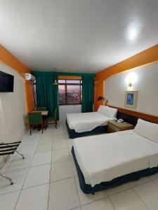 马瑙斯泰姬陵酒店 的酒店客房设有两张床和一张桌子。