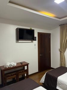 洛哈HOSTAL CAMIL的酒店客房设有两张床和一台墙上的电视。