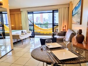 福塔莱萨Premium Flats - Praia Mansa的客厅配有沙发和带酒杯的桌子