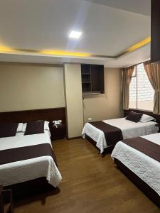 洛哈HOSTAL CAMIL的酒店客房设有两张床和窗户。