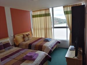 科恰班巴Hotel Angostura的酒店客房设有两张床和大窗户。