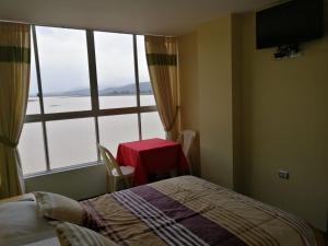 科恰班巴Hotel Angostura的一间卧室配有一张床、一张桌子和一个窗户。
