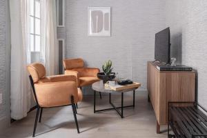 纽约Apartment 256: Upper West Side的客厅配有两把椅子、一台电视和一张桌子