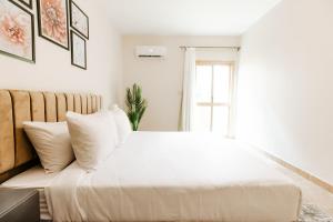 开罗The Garden Suites near CFC by ELEGANT的卧室配有白色的床和窗户。