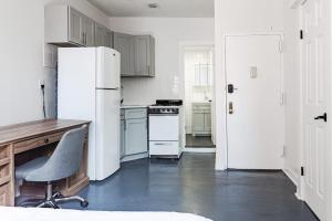 纽约Apartment 1407: East Village的厨房配有冰箱、书桌和椅子