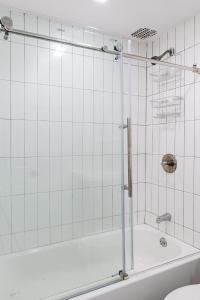 纽约Apartment 1407: East Village的浴室铺有白色瓷砖,设有淋浴。