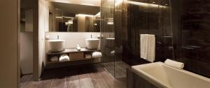 阿尔卑斯休斯山COMO Alpina Dolomites的浴室配有两个盥洗盆和浴缸。