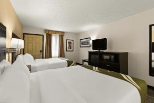 特拉弗斯城Quality Inn Traverse City的酒店客房设有两张床和一台平面电视。