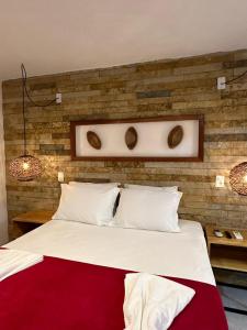 杰里科科拉Vila Biju Jeri的卧室配有一张白色大床和砖墙