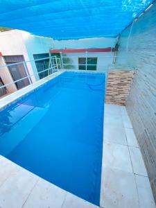 卡库佩Apartamento entero en Caacupé.的一座大型蓝色游泳池,设有砖墙