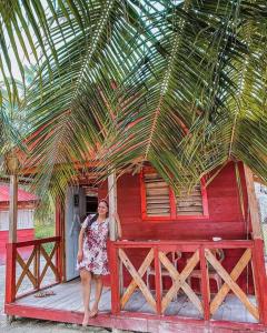 CagantupoCabaña privada en Guna Yala isla diablo baño compartido的站在红楼前的妇女