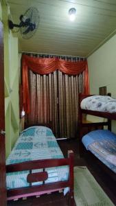 巴拉那皮亚卡巴Pousada Avalon Paranapiacaba的一间卧室设有两张双层床和一扇窗户。