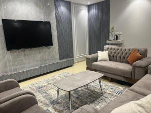 As Sayl aş Şaghīrشقق النخبة غرفتين وصالة的带沙发和平面电视的客厅