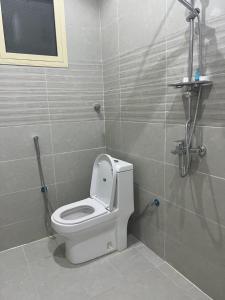 As Sayl aş Şaghīrشقق النخبة غرفة نوم وجلسة استديو的浴室位于隔间内,设有白色卫生间。