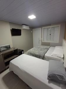 沙佩科Loft Lux 4的一间卧室配有两张床、一张桌子和一台电视。