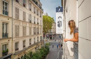 巴黎Hôtel Littéraire Arthur Rimbaud, BW Signature Collection的女人从建筑物的窗户望出去