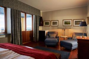 锡姆里斯港Hotel Svea - Sure Hotel Collection by Best Western的酒店客房,配有一张床和两把椅子