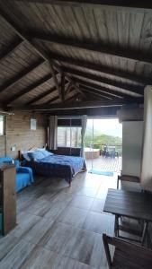 因比图巴Koa Cabana praia do luz的一间卧室设有两张床和木制天花板