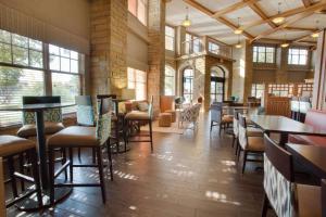 阿马里洛Drury Inn & Suites Amarillo的一间设有桌椅的餐厅,位于带窗户的房间内