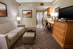 阿马里洛Drury Inn & Suites Amarillo的一间客厅,客厅配有沙发和一张书桌,位于酒店的房间