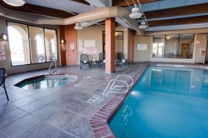 阿马里洛Drury Inn & Suites Amarillo的一个带桌椅的房间的游泳池