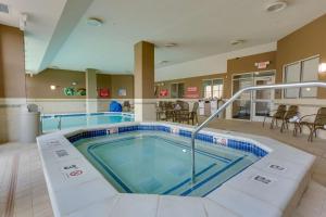 圣查尔斯Drury Plaza Hotel St. Louis St. Charles的游泳池位于带桌椅的房间中间