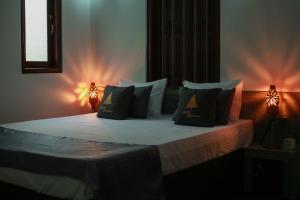 韦利格默Charming dark lodge in river的一间卧室配有带枕头和2盏灯的床。