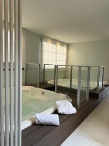萨尔塔Guemes Hotel & Spa的带浴缸和床的大型浴室