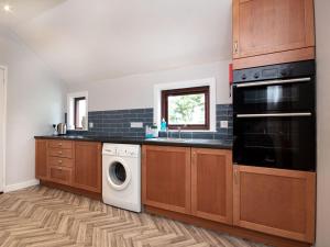 布罗拉Auld House的厨房配有木制橱柜、洗衣机和烘干机
