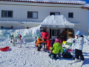 富山白色奇迹旅馆的一群站在建筑物前雪中的孩子