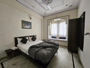 乌代浦Madpackers Udaipur的一间带一张大床的卧室,位于带窗户的房间内