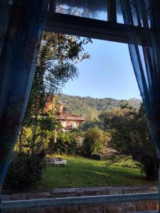 巴拉那皮亚卡巴Pousada Shamballah Paranapiacaba的从房子的窗户欣赏庭院的景色