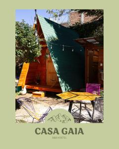 圣克里斯托瓦尔-德拉斯卡萨斯Hostal Casa Gaia的绿色屋顶房屋,配有桌椅