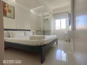 长滩岛麦卡萨酒店的一间卧室配有一张带白色床单的大床