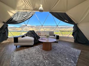 克伦威尔Glamping Dome - Rosé的客厅设有一张桌子和一个大帐篷