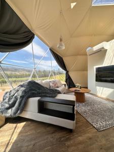 克伦威尔Glamping Dome - Rosé的帐篷内一间卧室,配有一张床