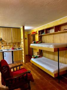 瓦托内切Casa del Lago的带两张双层床和厨房的客房